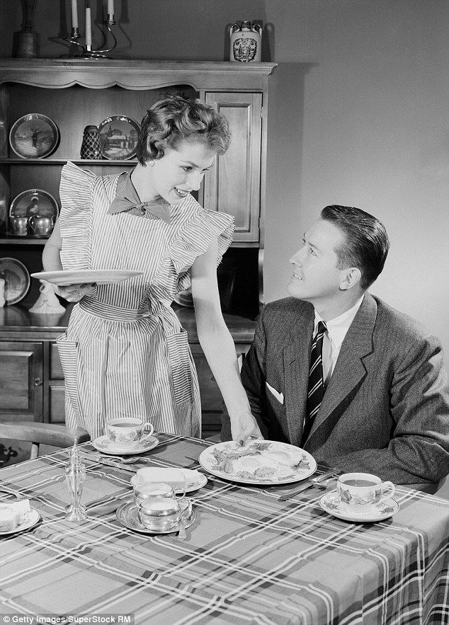 A black and white photo of a woman serving breakfast to her husband at a dining table. A black and white photo of a woman serving breakfast to her husband at a dining table.