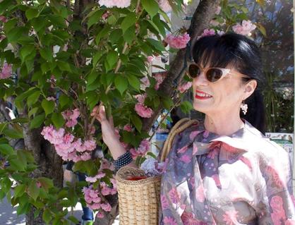 A tree in full bloom with a woman in a vinatge outfit. A tree in full bloom with a woman in a vinatge outfit.